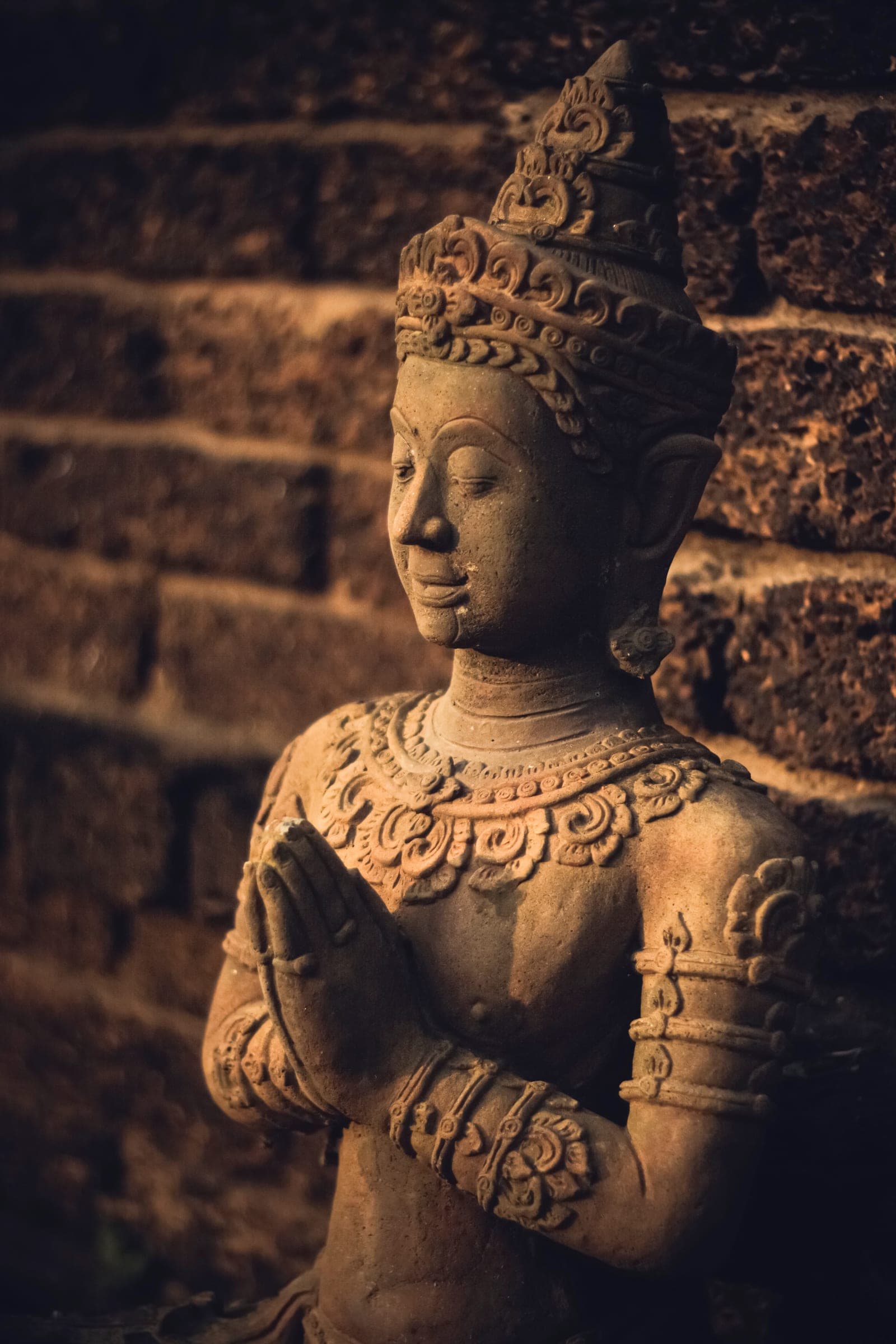 Stone statue with hands folded in a prayer gesture